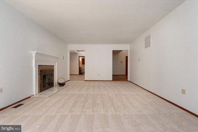 unfurnished living room with light carpet, visible vents, baseboards, and a brick fireplace
