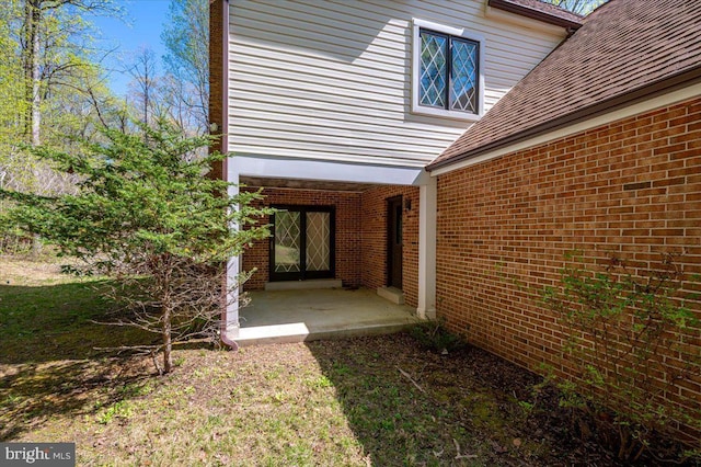 view of side of home with french doors and brick siding
