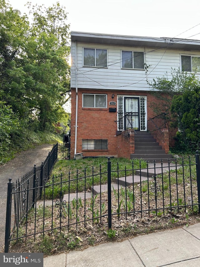 view of front facade featuring a fenced front yard and brick siding