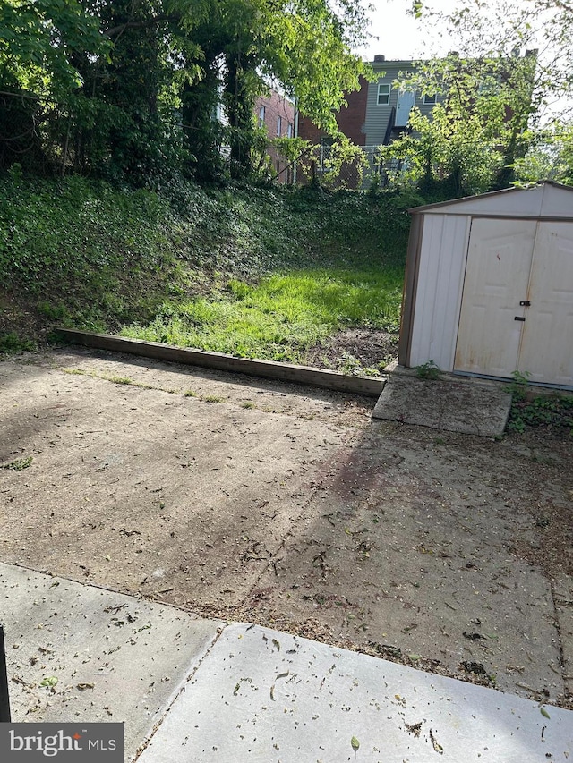 view of yard featuring a storage shed, fence, and an outdoor structure