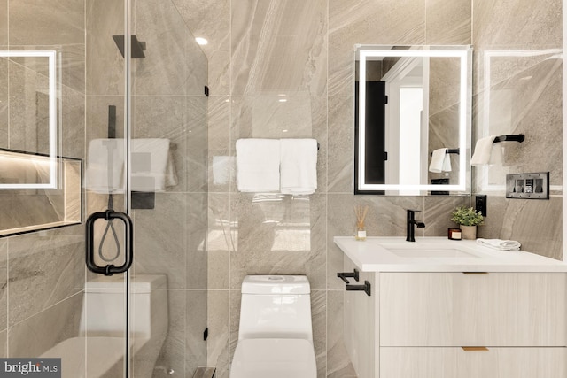 bathroom featuring vanity, a stall shower, toilet, and tile walls