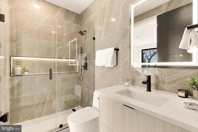 bathroom featuring decorative backsplash, tile walls, a stall shower, vanity, and toilet