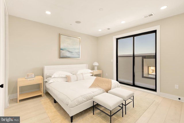 bedroom featuring visible vents, light wood finished floors, baseboards, and access to outside