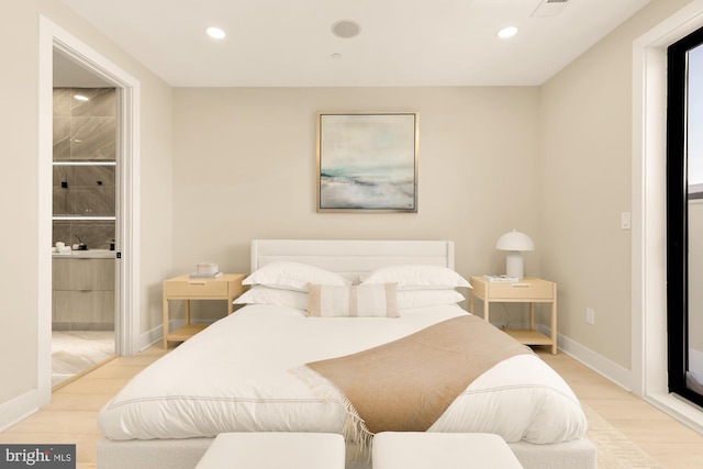 bedroom with recessed lighting, baseboards, light wood-type flooring, and ensuite bath
