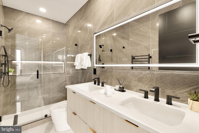 full bath featuring toilet, tile walls, a shower stall, and a sink