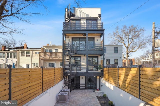 rear view of house with stairs, a fenced backyard, a balcony, central air condition unit, and a ceiling fan