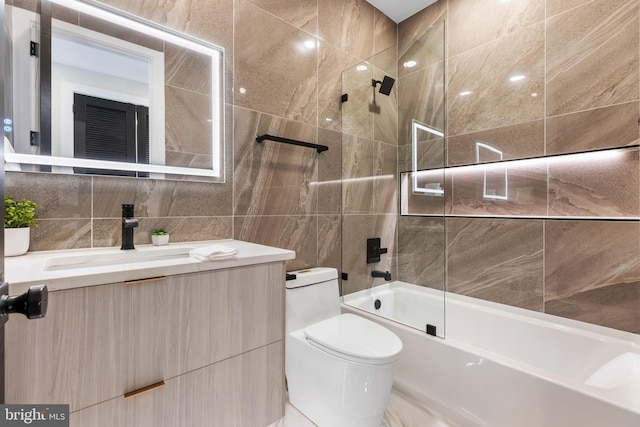 full bathroom featuring toilet, shower / bath combination, tile walls, and vanity