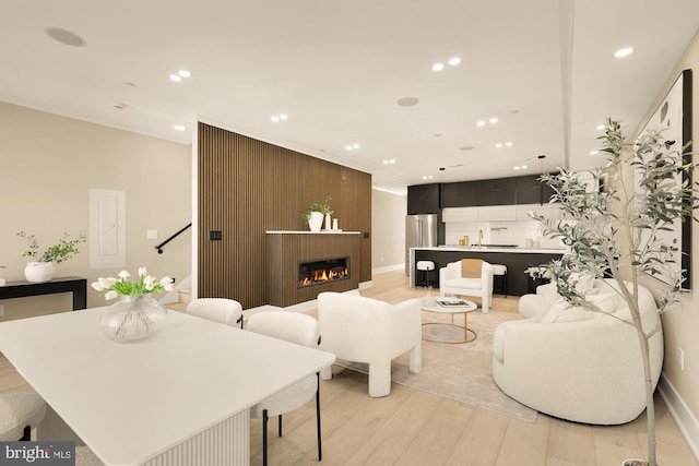 living area with a fireplace, recessed lighting, baseboards, and light wood-style floors