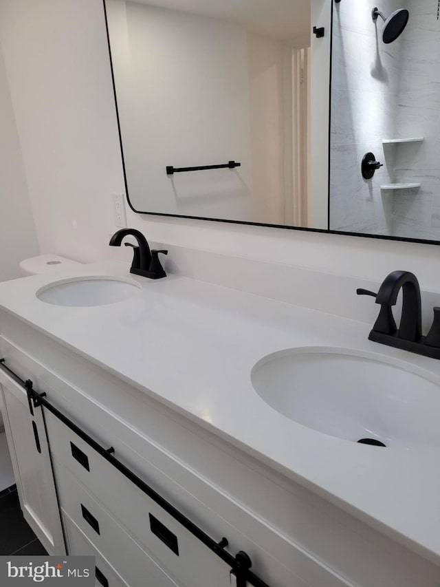 bathroom featuring a sink, tile patterned floors, a shower, and double vanity