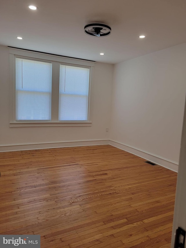 empty room featuring visible vents, baseboards, recessed lighting, and wood finished floors