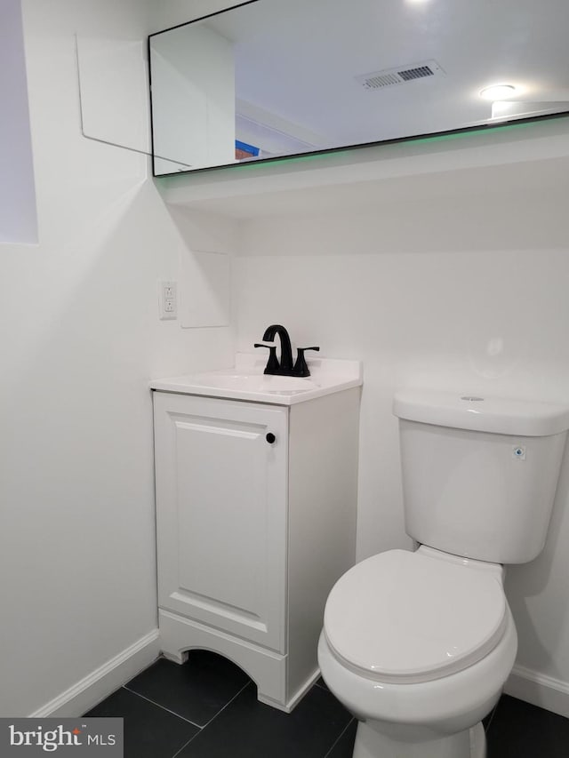 bathroom featuring vanity, baseboards, tile patterned flooring, toilet, and visible vents