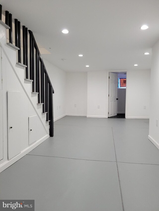 basement featuring recessed lighting, baseboards, and stairs