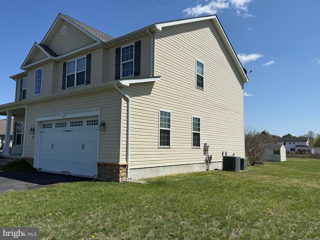 97 S Nightingale Dr, Milford, DE 19963 - view of side of property featuring cooling unit, an attached garage, aphalt driveway, and a lawn