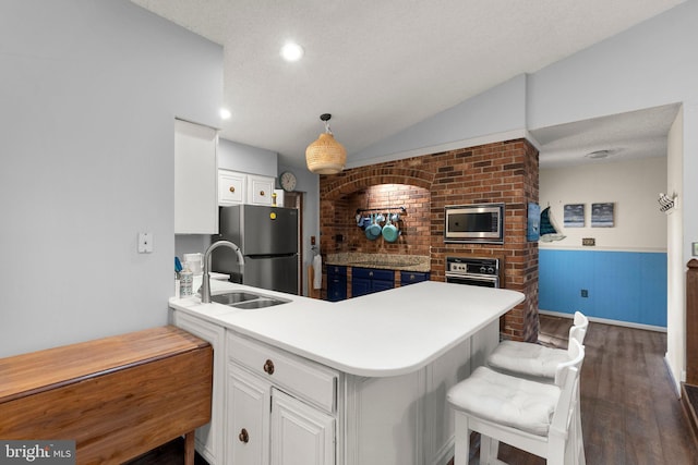 2200 Harpoon Dr, Stafford, VA 22554 - kitchen featuring a sink, appliances with stainless steel finishes, dark wood-style floors, white cabinetry, and a peninsula
