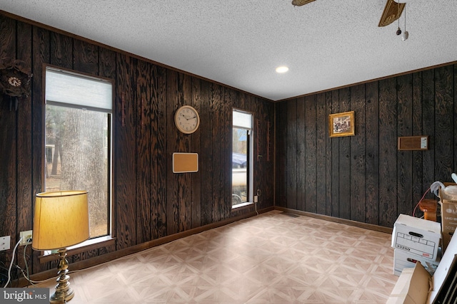 2200 Harpoon Dr, Stafford, VA 22554 - unfurnished room featuring healthy amount of natural light, baseboards, wood walls, a textured ceiling, and a ceiling fan