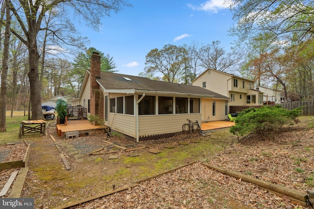 2200 Harpoon Dr, Stafford, VA 22554 - back of property with a wooden deck, a chimney, a sunroom, a vegetable garden, and roof with shingles