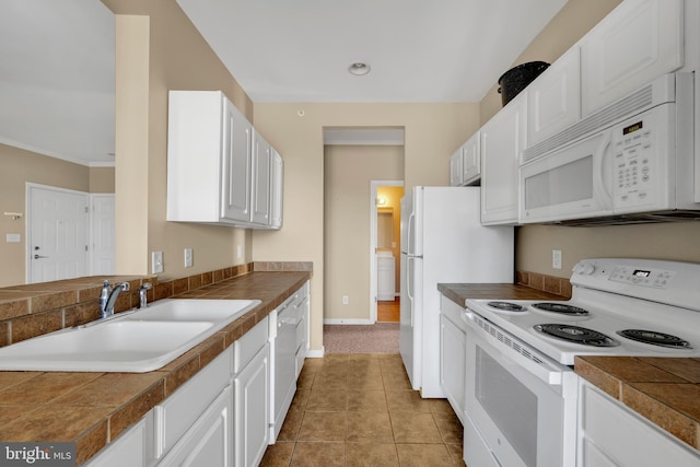 kitchen with tile patterned flooring, white appliances, tile counters, white cabinetry, and a sink
