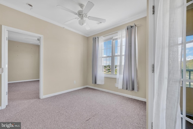 carpeted empty room featuring ornamental molding, ceiling fan, and a wealth of natural light