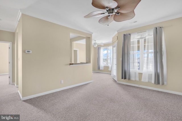 carpeted spare room featuring baseboards, ornamental molding, and ceiling fan