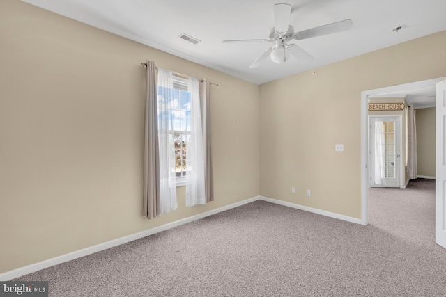 empty room featuring baseboards, carpet, a ceiling fan, and visible vents