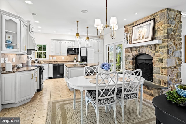 dining room with a stone fireplace, recessed lighting, plenty of natural light, and light tile patterned flooring