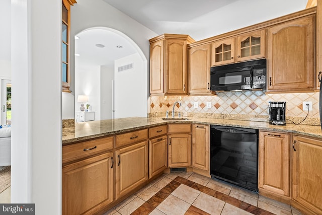 kitchen with a sink, backsplash, black appliances, and visible vents
