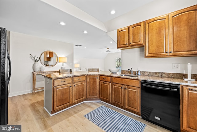kitchen featuring light wood-type flooring, a sink, a ceiling fan, and black appliances