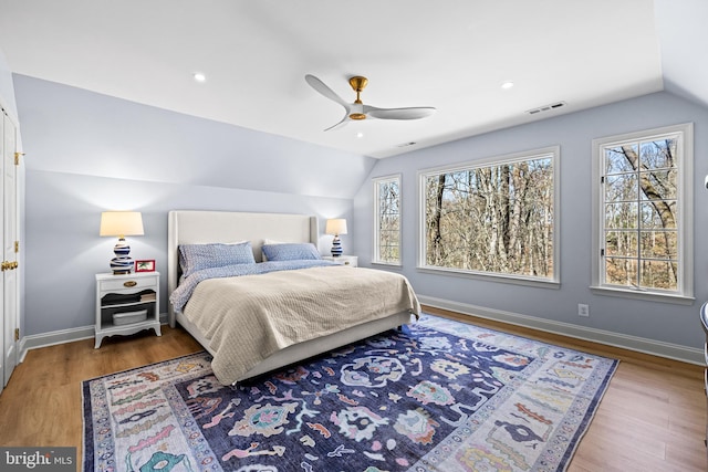 bedroom with visible vents, baseboards, wood finished floors, and lofted ceiling