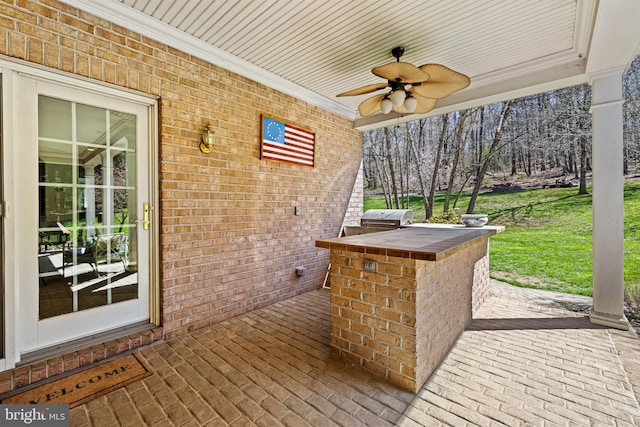 wooden deck with grilling area and a ceiling fan