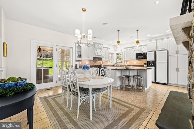dining room with light tile patterned flooring, an inviting chandelier, and recessed lighting