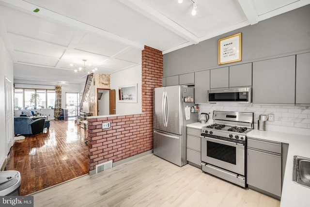 kitchen with light wood-type flooring, gray cabinets, open floor plan, visible vents, and appliances with stainless steel finishes