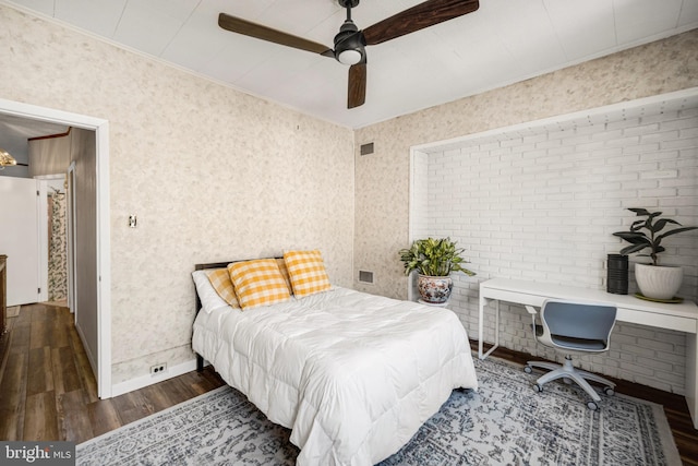 bedroom with baseboards, wallpapered walls, ornamental molding, and wood finished floors
