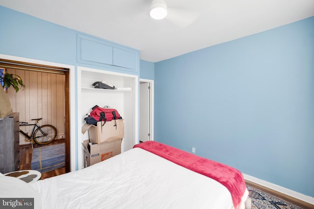 bedroom with dark wood-style flooring and baseboards