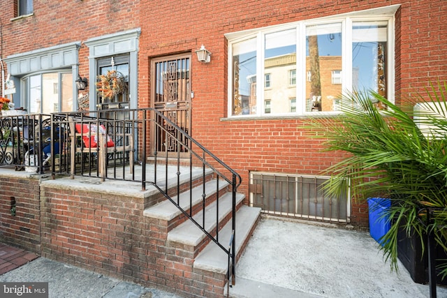 doorway to property featuring brick siding