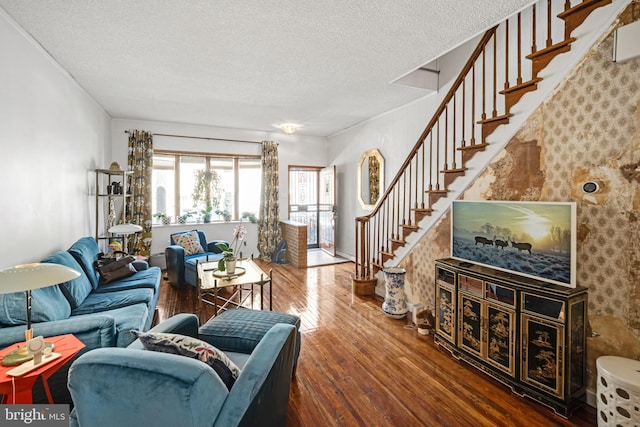 living room with stairs, hardwood / wood-style flooring, and a textured ceiling