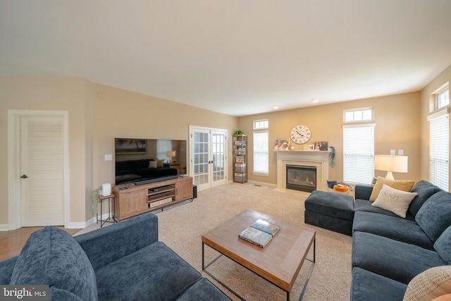 869 Bourban Ln, West Grove, PA 19390 - living area with healthy amount of natural light, a glass covered fireplace, light colored carpet, and french doors