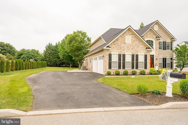 869 Bourban Ln, West Grove, PA 19390 - view of front of home with stone siding, asphalt driveway, a front yard, and a garage