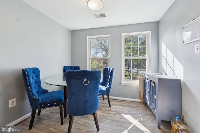 dining area with light wood-style floors, visible vents, and baseboards