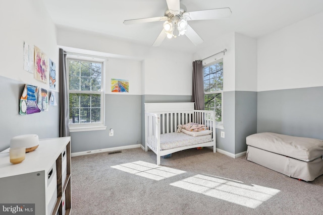 bedroom with baseboards, a ceiling fan, visible vents, and carpet
