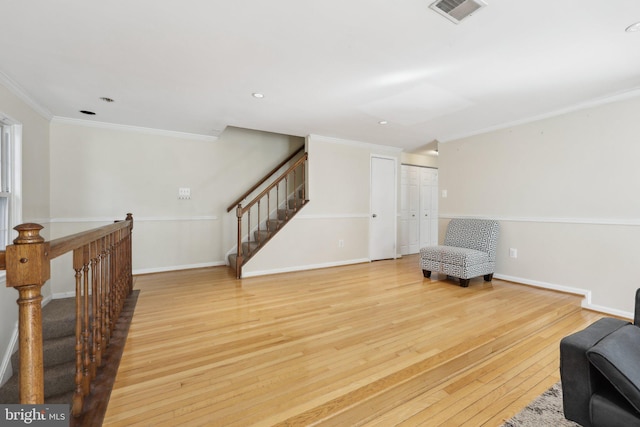 living area featuring crown molding, stairs, wood finished floors, baseboards, and visible vents