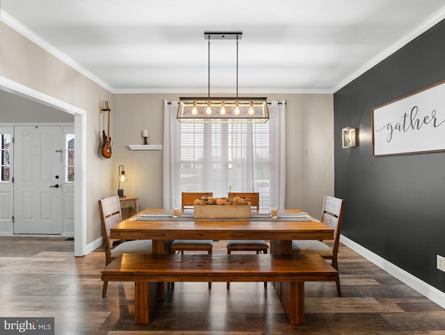 dining area featuring crown molding, baseboards, and wood finished floors