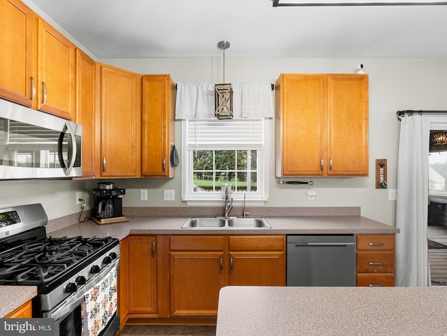 kitchen with a sink, decorative light fixtures, and stainless steel appliances