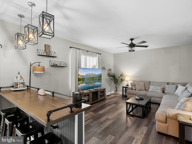 living area featuring baseboards, a ceiling fan, and dark wood finished floors
