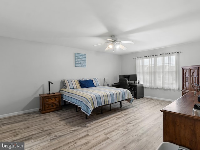 bedroom featuring wood finished floors, baseboards, and a ceiling fan