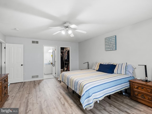 bedroom with light wood-type flooring, a closet, a spacious closet, and visible vents