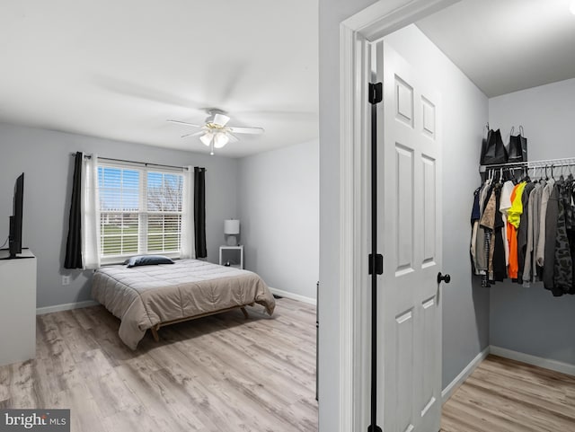 bedroom featuring baseboards, ceiling fan, and light wood-style floors