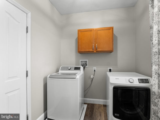 washroom with washing machine and dryer, dark wood-style flooring, baseboards, and cabinet space