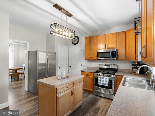 kitchen with a sink, light countertops, appliances with stainless steel finishes, and dark wood finished floors