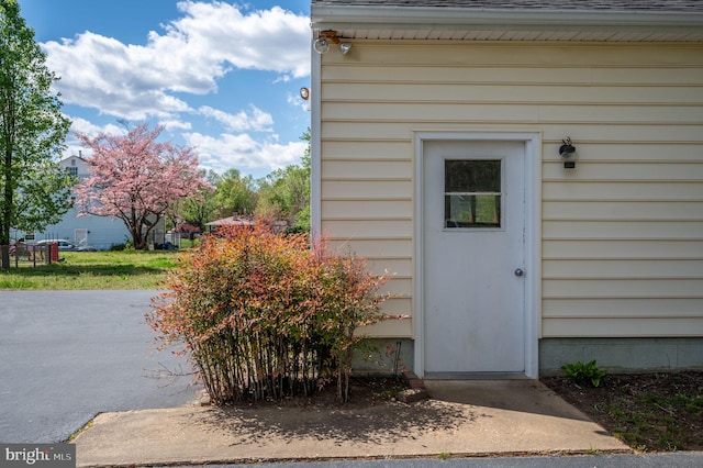 view of exterior entry with a shingled roof