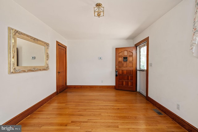 corridor featuring visible vents, light wood finished floors, and baseboards